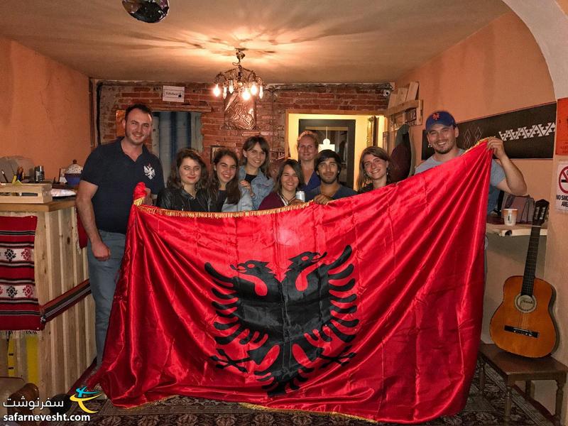 A photo with guests and Albania's flag in ODA hostel