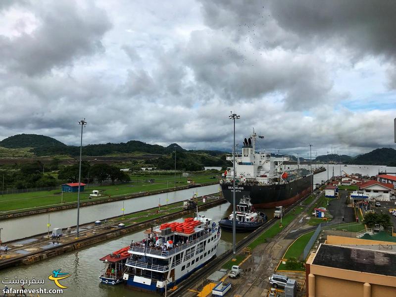 یک کشتی بزرگ که همه عرض کانال پاناما رو گرفته در جلو و یک کشتی توریستی در عقب